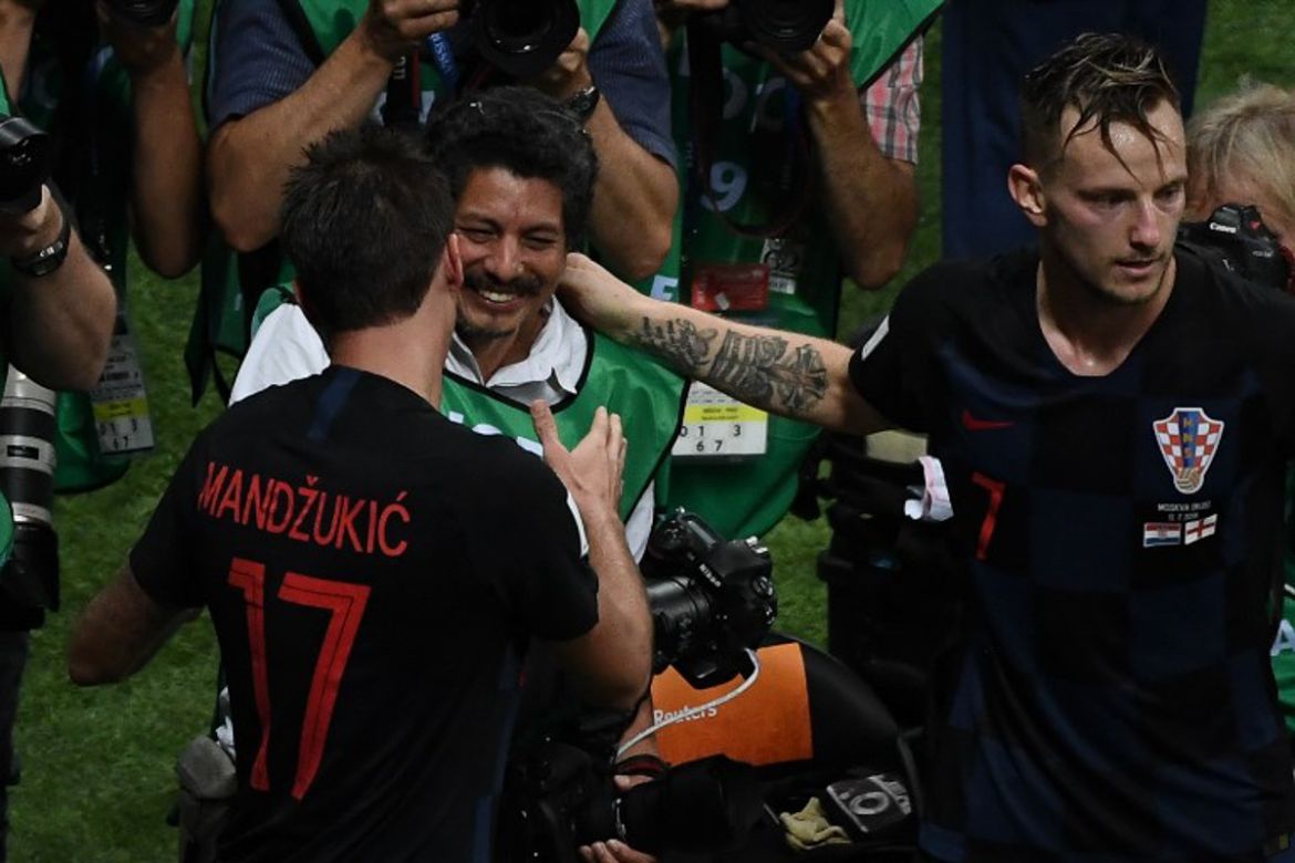 Croatia''s forward Mario Mandzukic (L) speaks to AFP photographer Yuri Cortez (C) after falling on him with teammates while celebrating scoring his team''s second goal during the Russia 2018 World Cup s