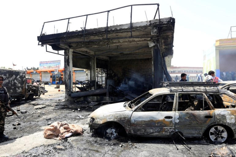 Afghan security forces inspect the site of a suicide attack in Jalalabad city
