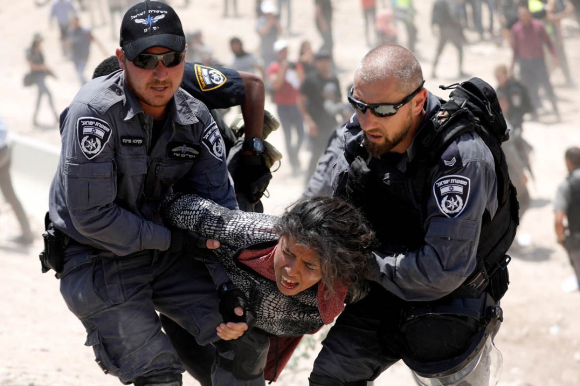 Israeli policemen detain a Palestinian girl in the Palestinian Bedouin village of al-Khan al-Ahmar near Jericho in the occupied West Bank July 4, 2018. REUTERS/Mohamad Torokman