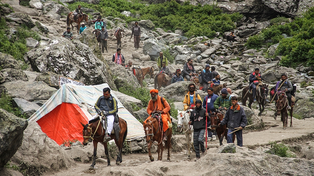 Locals charge $100 to take pilgrims to the cave by pony [Sameer Mushtaq/Al Jazeera]