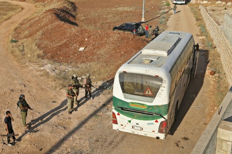 Members of Hayat Tahrir al-Sham group, led by Syria''s former Al-Qaeda affiliate, watch as a convoy of busses gets ready to enter the towns of Fuaa and Kefraya to evacuate their residents on July 18, 2