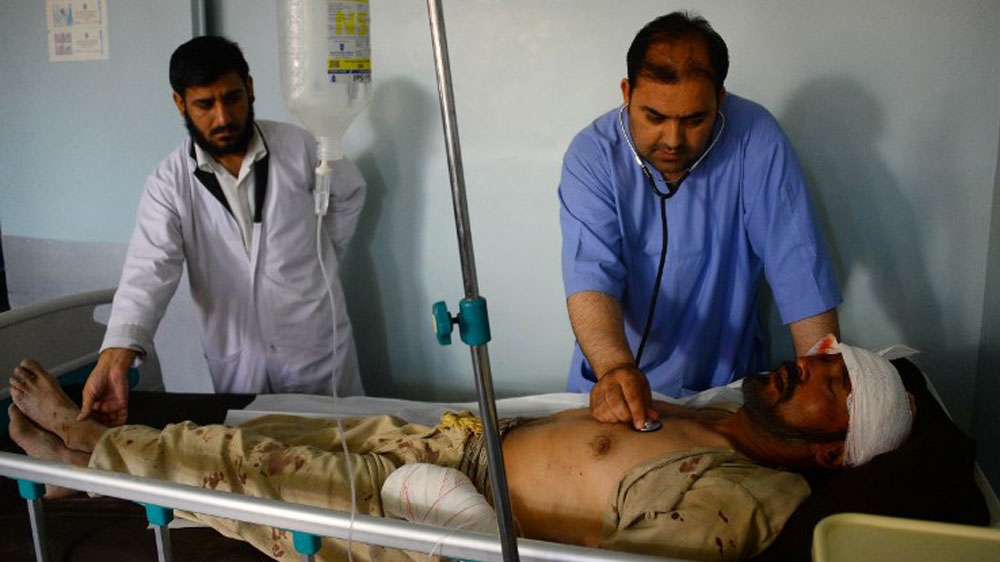 Afghan medical staff treat a wounded man in a hospital in Herat [Hoshang Hashimi/AFP]