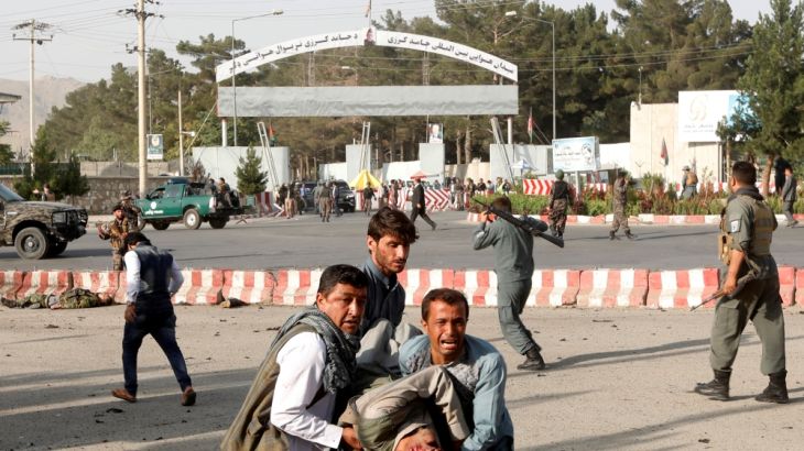 Members of Afghan security forces carry a victim at the site of a blast in Kabul