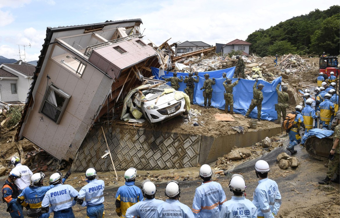 Rescue workers look for missing people in a house damaged by heavy rain in Kumano town, Hiroshima Prefecture, Japan, in this photo taken by Kyodo July 9, 2018. Mandatory credit Kyodo/via REUTERS