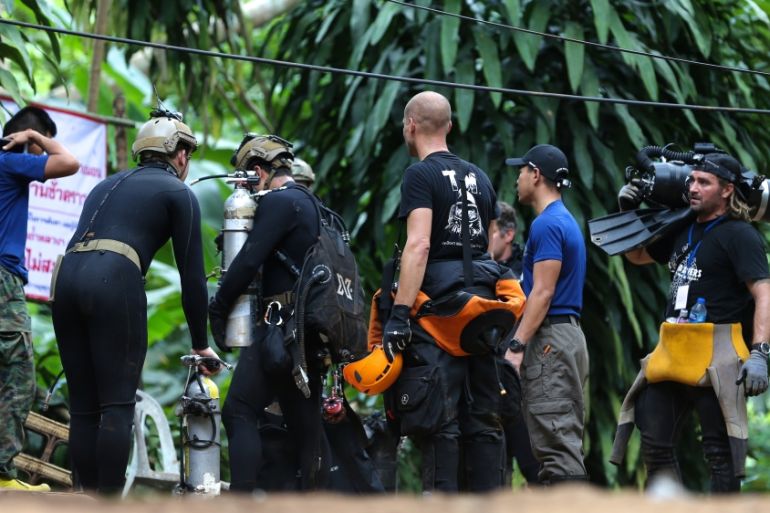 International divers carry equipments as they prepare to go in to Tham Luang cave complex, as members of an under-16 soccer team and their coach have been found alive in Thailand