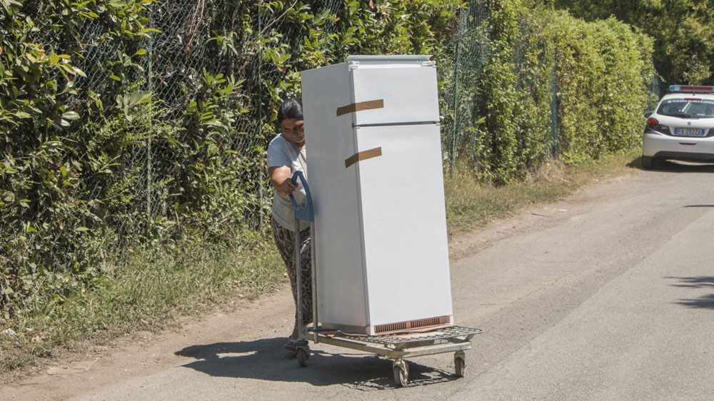 An evicted resident hauls away her fridge with nowhere to go [Ylenia Gostoli/Al Jazeera] 