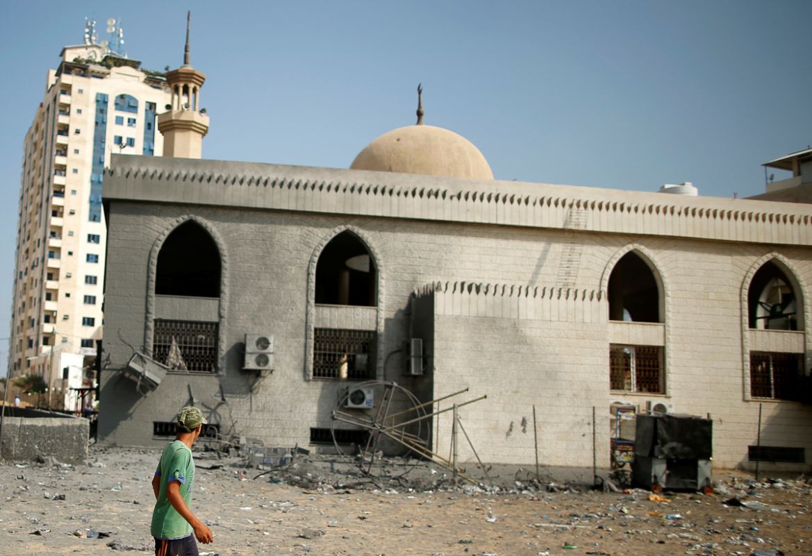 A Palestinian walks past Sheikh Zayed mosque that was damaged by Israeli air strikes in Gaza City, July 15, 2018. REUTERS/Suhaib Salem