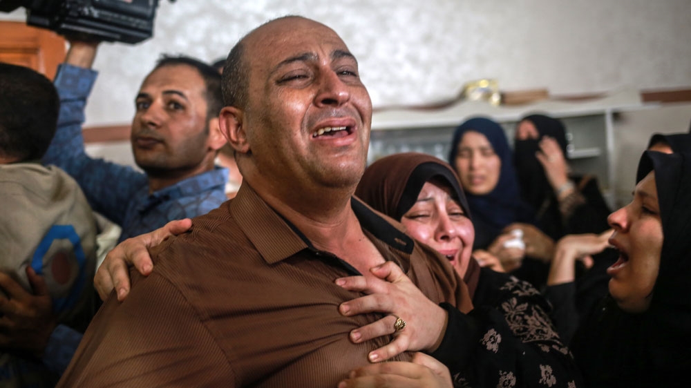 The father of Amir al-Nimra mourns after the funeral of his son [Hosam Salem/Al Jazeera]