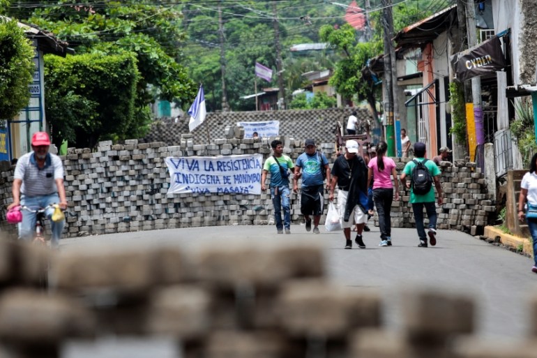 People walk through barricades in the indigenous community of Monimbo in Masaya