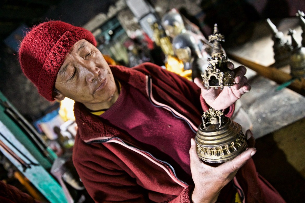 3. A monk reveals intricately crafted Gods hidden inside a copper stupa in Namygal Monastery in Mustang, Nepal. These rare idols are highly sought after by thieves, and the monastery has been forced