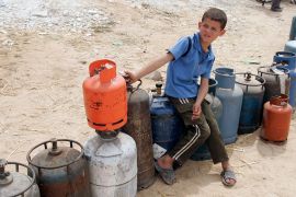 A Palestinian boy waits to fill cooking gas canisters at a gas station in Gaza May 13, 2008. Israel resumed fuel shipments to Gaza''s main power station on Monday, a senior generating plant official s