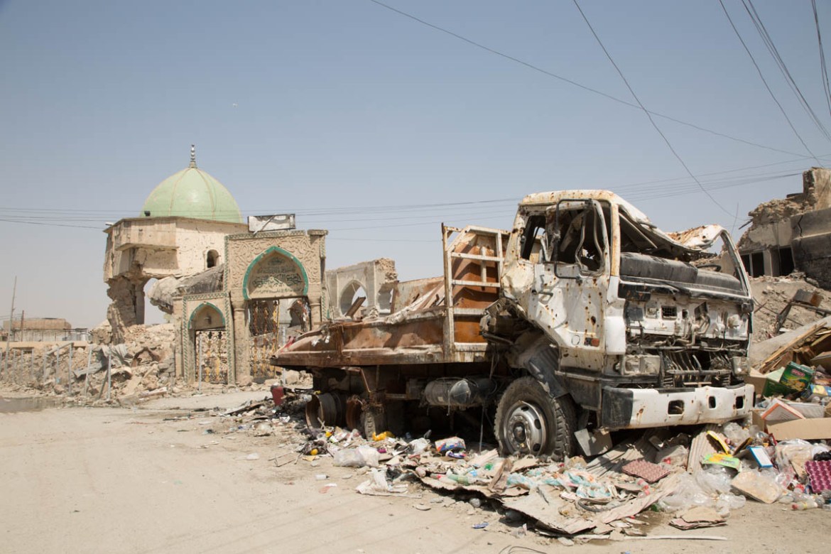 Photo 8 The remains of a truck in front of the Great Mosque of al-Nuri. The shape of the truck on the bullet impacts on it illustrates the intensity of the fighting that took place in that area one y