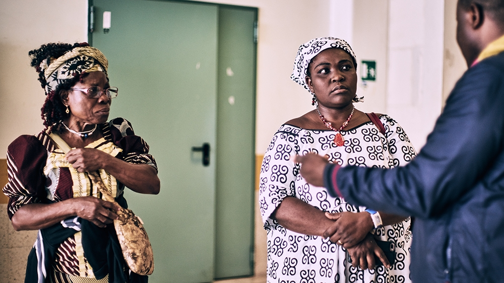 Egbon, right, and Doris visit a girl in hospital who had jumped from a window to escape her trafficker [Naomi Morello/Al Jazeera]