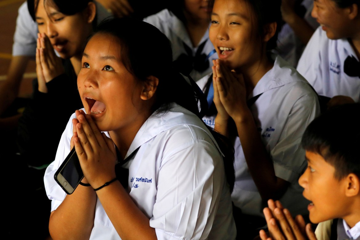 Classmates pray after their teacher announced some of the 12 schoolboys trapped inside a flooded cave have been rescued, at Mae Sai Prasitsart school, in the northern province of Chiang Rai, Thailand