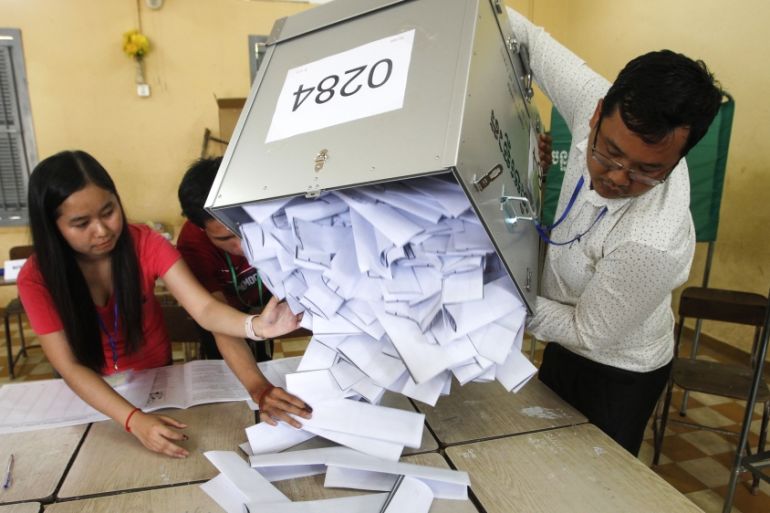 Polling station officials empty ballots boxes before counting at a polling station in Phnom Penh, Cambodia, Sunday, July 29, 2018. With the main opposition silenced, Cambodians were voting in an elect