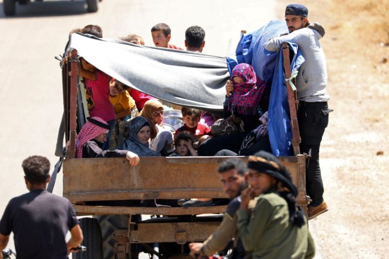 Internally displaced people from Deraa province ride on a back of a truck near the Israeli-occupied Golan Heights in Quneitra