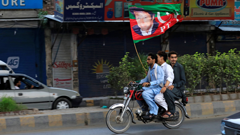 Supporters of PTI's Imran Khan wave a party flag in Rawalpindi [Faisal Mahmood/Reuters]