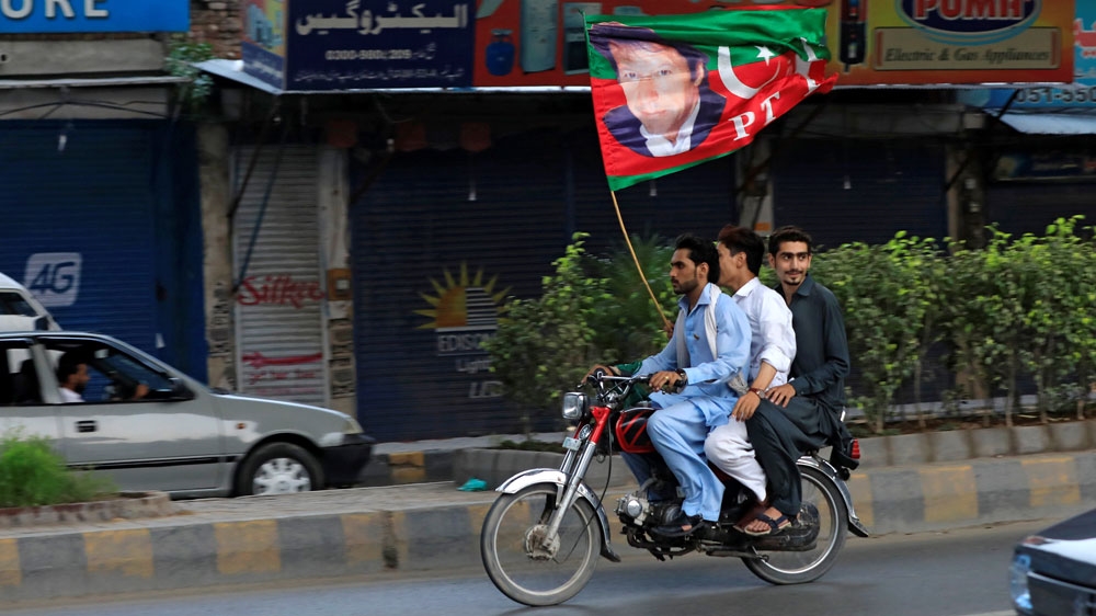 Supporters of Imran Khan wave a party flag as they celebrate PTI party's victory [Faisal Mahmood/Reuters]