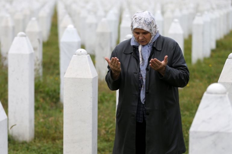 Hatidza Mehmedovic prays near the graves of her two sons and husband in Memorial Center in Potocari near Srebrenica