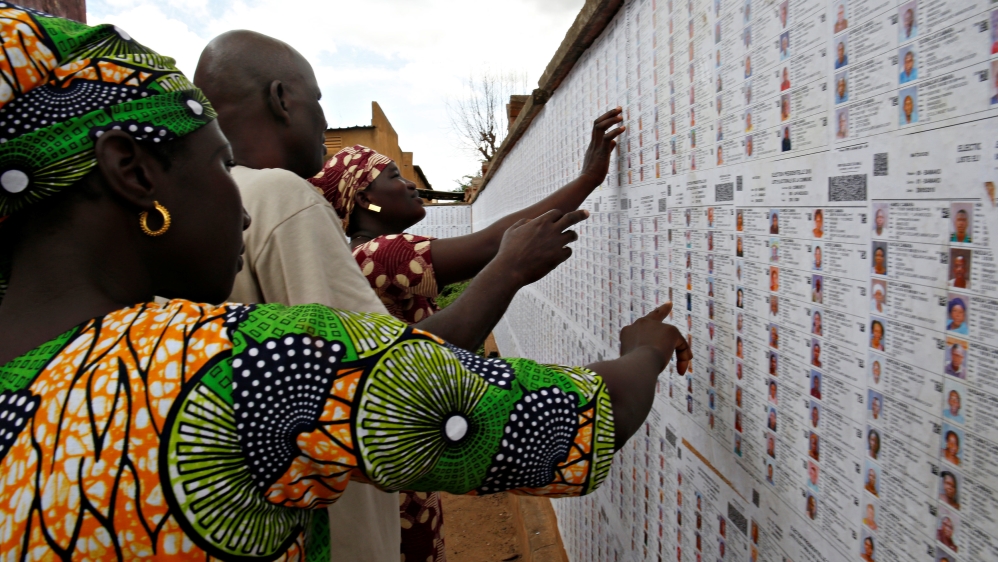 People look for their names on the electoral list at a polling station in Bamako [Luc Gnago/Reuters]