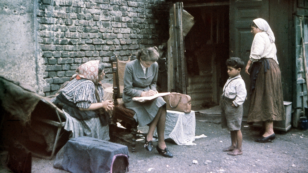 Eva Justin of the Racial Hygiene Research Centre at the Reich Bureau for Health at the Reichsgesundheitsamt conducting interview with an old woman in 1938. Her research provided the pseudo-scientific basis for the extermination and forced sterilization of thousands of Sinti and Roma. After completion of the research, deportations to Poland started [File: Galerie Bilderwelt/Getty Images]