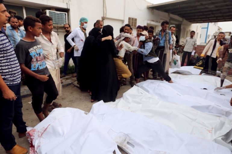 Relatives of victims gather around their bodies outside a hospital morge after an air strike hit a fish market in Hodeidah