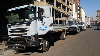 Police trucks parked outside the opposition headquarters [Hamza Mohamed/Al Jazeera]