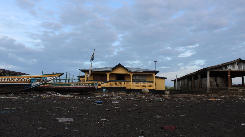 The chief’s house sits at the edge of Yelibuya, furthest from the rising water. Still, the ground in front of it remains soggy. It’s the only house in town with light, as local taxes have been used to buy solar panels [Mara Kardas-Nelson/Al Jazeera]