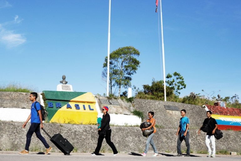 Venezuelans walk across the border from Venezuela into the Brazilian city of Pacaraima, Roraima state