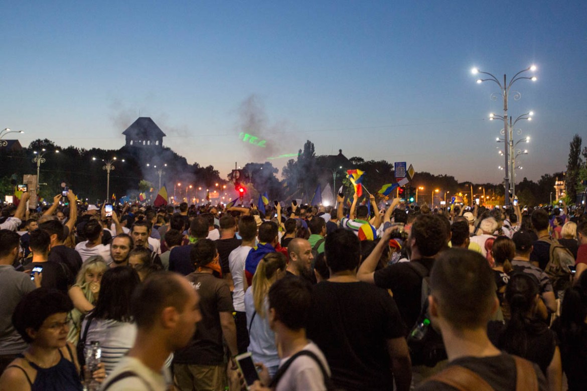 Laser anti government messages were projected as tear gas rose from the crowd on Friday evening, during the biggest anti-corruption protest in the last months. [Alexandra Radu/Al Jazeera]