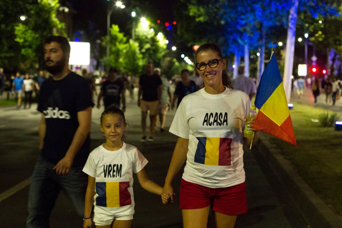 Protesters wearing t-shirs writing “We want home” walked towards the Victory square in Bucharest. [Alexandra Radu/Al Jazeera]
