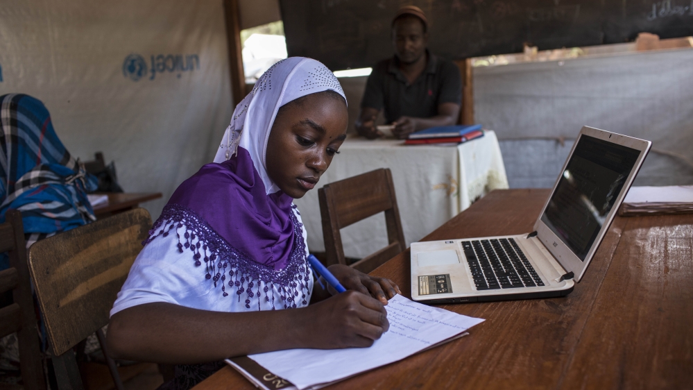 Oussna Abdraman, 17, takes notes while studying at the computer lab on the grounds of the Bangassou Catholic mission [Will Baxter/Al Jazeera]