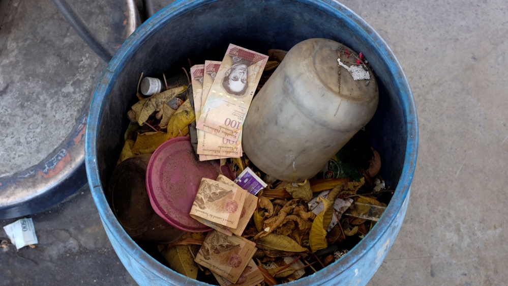 Venezuelan 100 bolivar notes thrown by people in a trash bin are seen at a gas station[Marco Bello/Reuters]