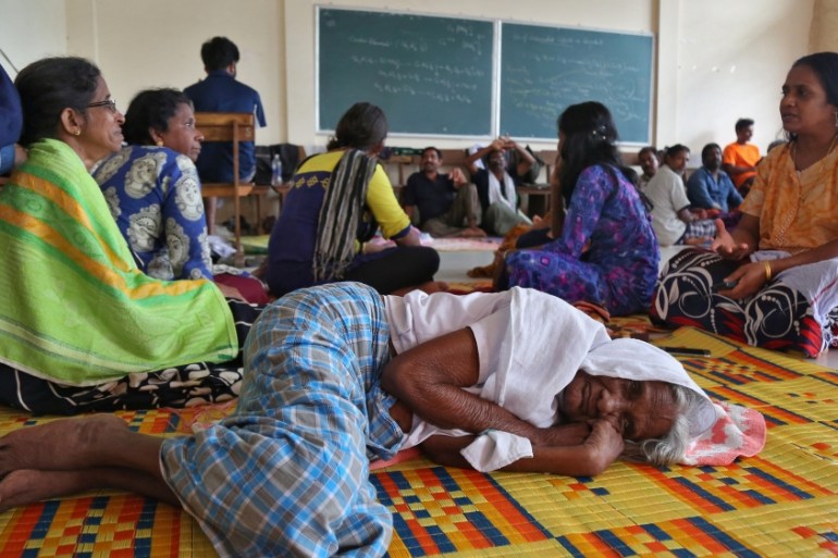 Flood victims rest inside a university classroom, which is converted into a temporary relief camp in Kochi