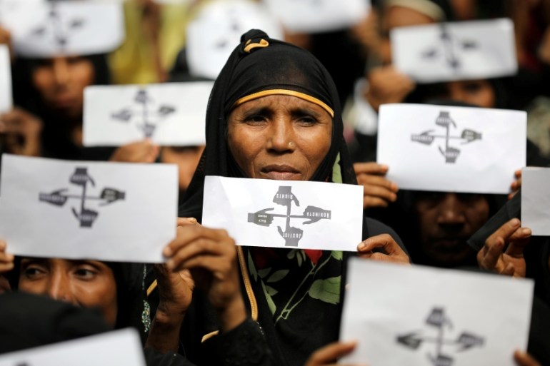 Rohingya refugee women hold placards as they take part in a protest at the Kutupalong refugee camp to mark the one-year anniversary of their exodus in Cox''s Bazar