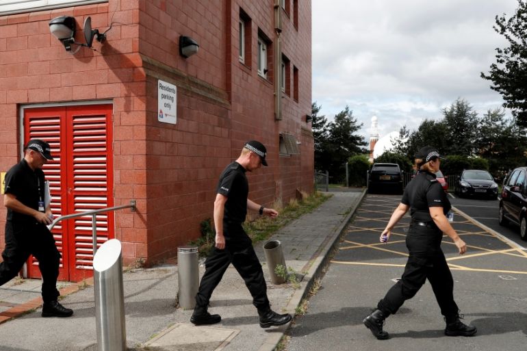 Police officers search a block of flats in Birmingham