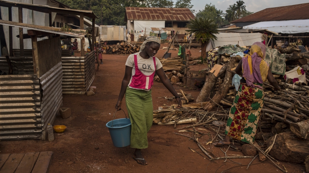 A displaced Muslim woman carries water at the settlement in Bangassou [Will Baxter/Al Jazeera]