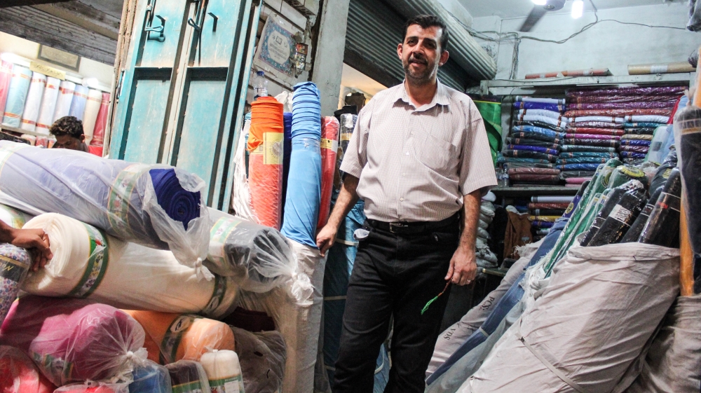 Assad Baldawi, 44, moved into the old market in 2003 and now owns two fabric stalls [Arwa Ibrahim/Al Jazeera]