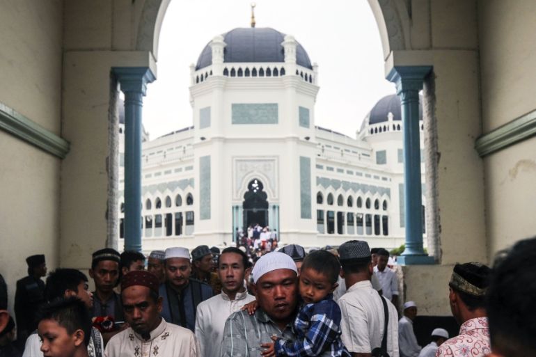 Indonesian Muslims walk out of a mosque after attending the Eid al-Adha prayers in Medan, North Sumatra, Indonesia