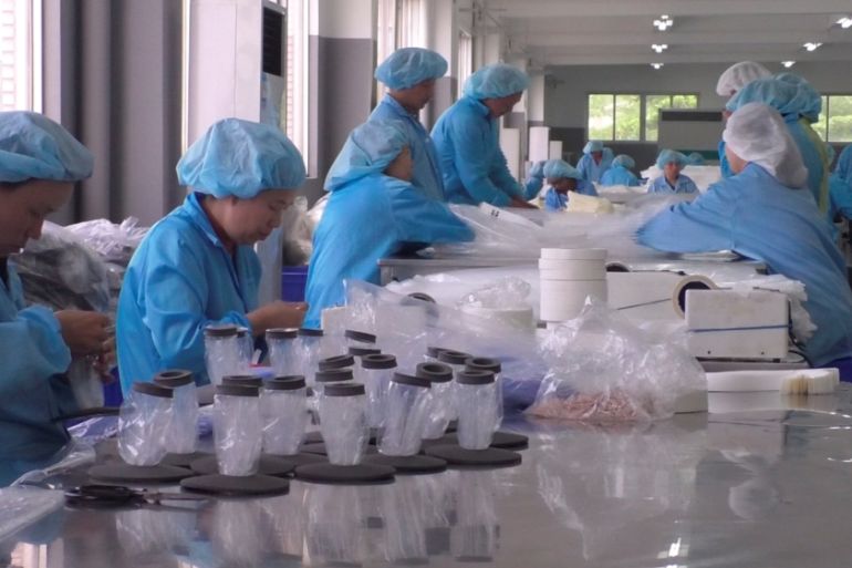 Workers manufacture medical supplies at a factory in Guangzhou, in this still image taken from Reuters TV footage