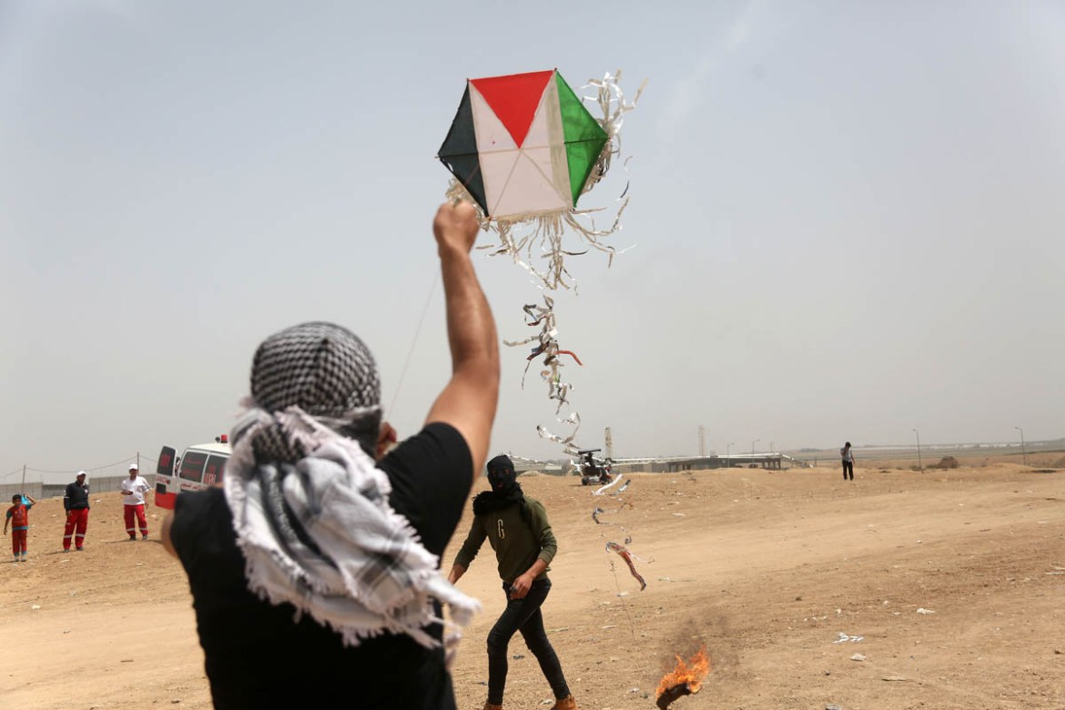 A Palestinian launches a kite carrying a Molotov cocktail over the Gaza fence, during the 3rd week of the #GreatReturnMarch campaign, April 20, 2018. Kites attached to flammable materials have caused