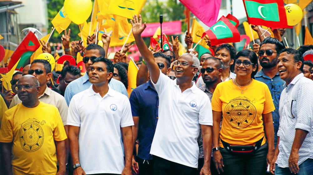 Ibrahim Mohamed Solih, Maldivian presidential candidate backed by the opposition coalition, waves as he stands next to his supporters during the final campaign rally ahead of the presidential election in Male, Maldives on September 22, 2018 [Reuters/Ashwa Faheem]