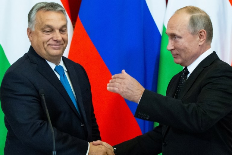 Russian President Putin shakes hands with Hungarian PM Orban during a joint news conference following their talks at the Kremlin in Moscow