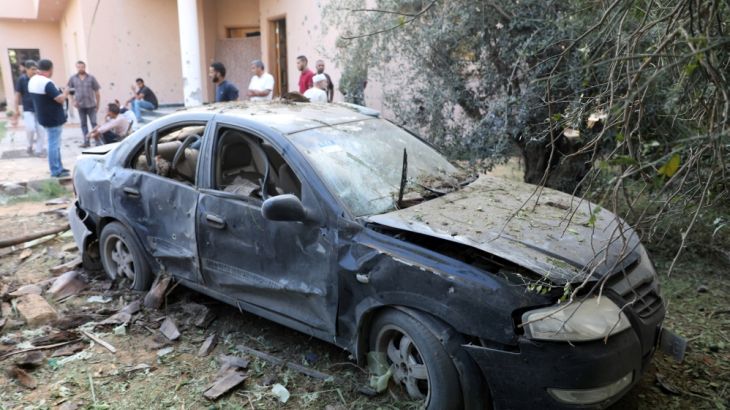 A damaged car is seen during clashes between rival factions in Tripoli, Libya