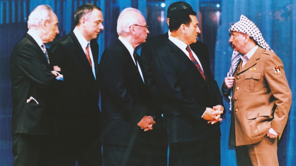 PLO Chairman Yasser Arafat stands apart as Israeli FM Shimon Peres, Russian FM Andrei Kozyrev, Israeli PM Yitzhak Rabin and Egyptian President Hosni Mubarak try to persuade him to sign the Israeli-PLO autonomy accord document in Cairo, Egypt, May 4, 1994, after a dispute over a map of Jericho. Arafat eventually signed [AP]