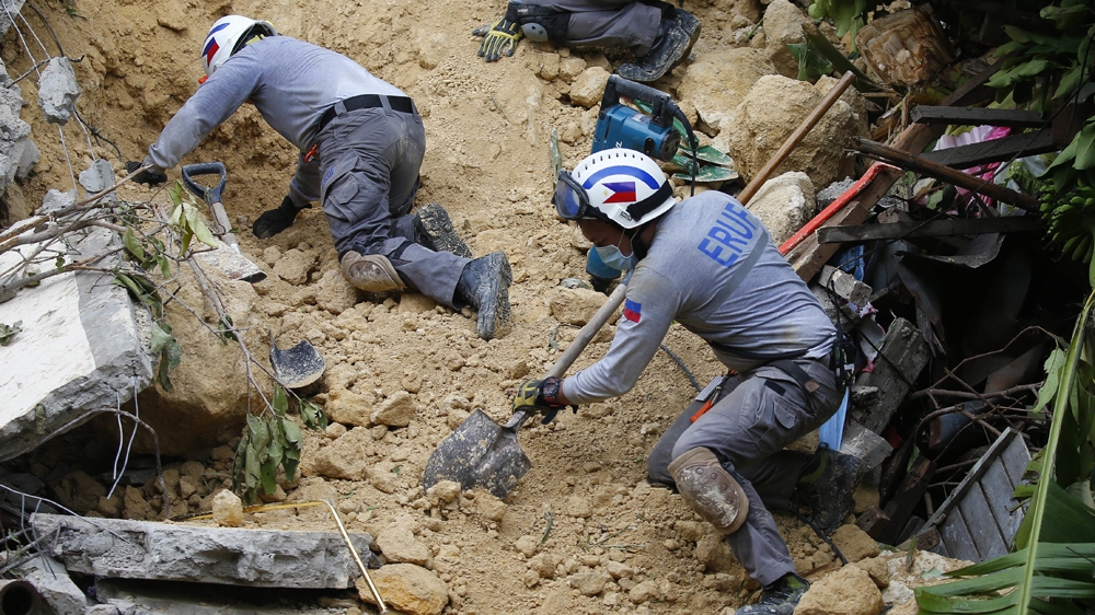 Many workers were using shovels to dig on the second day of the rescue operation [Bullit Marquez/The Associated Press]