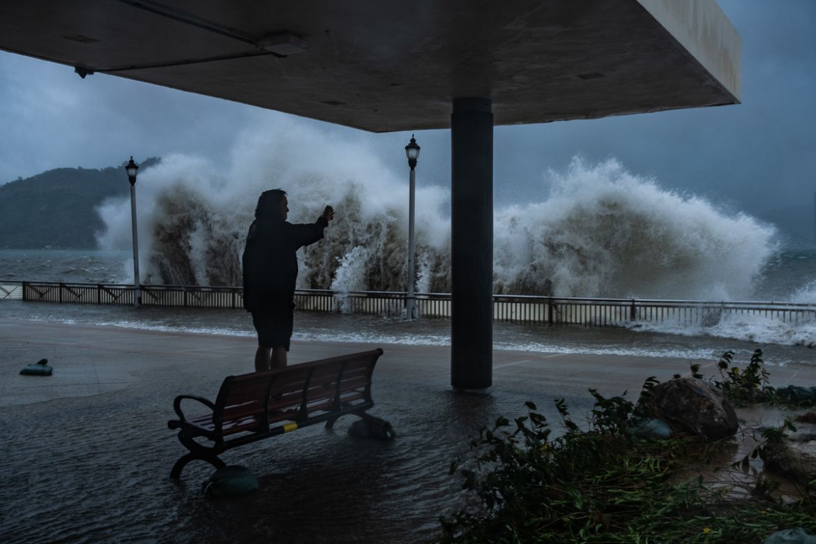 HONG KONG, HONG KONG - SEPTEMBER 16: A man takes photograph at the seafront on September 16, 2018 in Hong Kong, Hong Kong. City officials raised the storm alert to T10, it''s highest level, as Typhoon