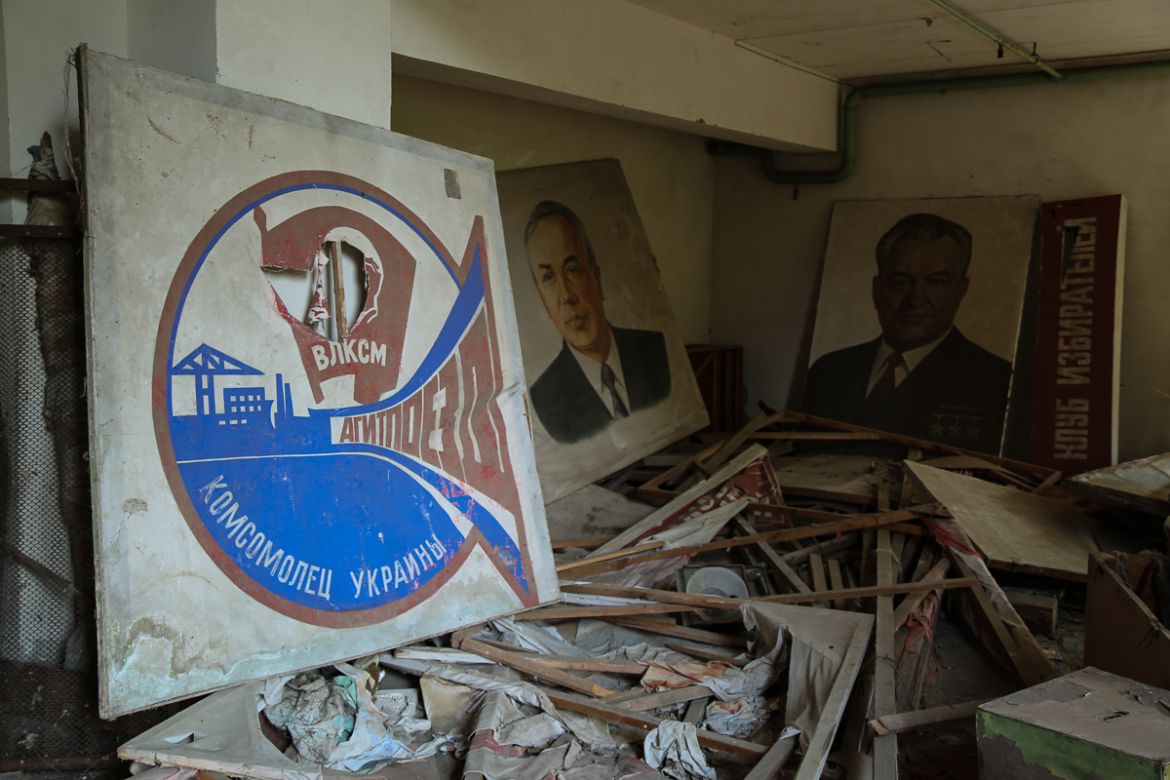 Soviet-era posters and signs in Pripyat’s ruined community theatre. [Blake Sifton/Al Jazeera]