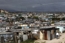 Residents walk through shacks in Cape Town''s crime-ridden Khayelitsha township in this picture taken July 9, 2012.