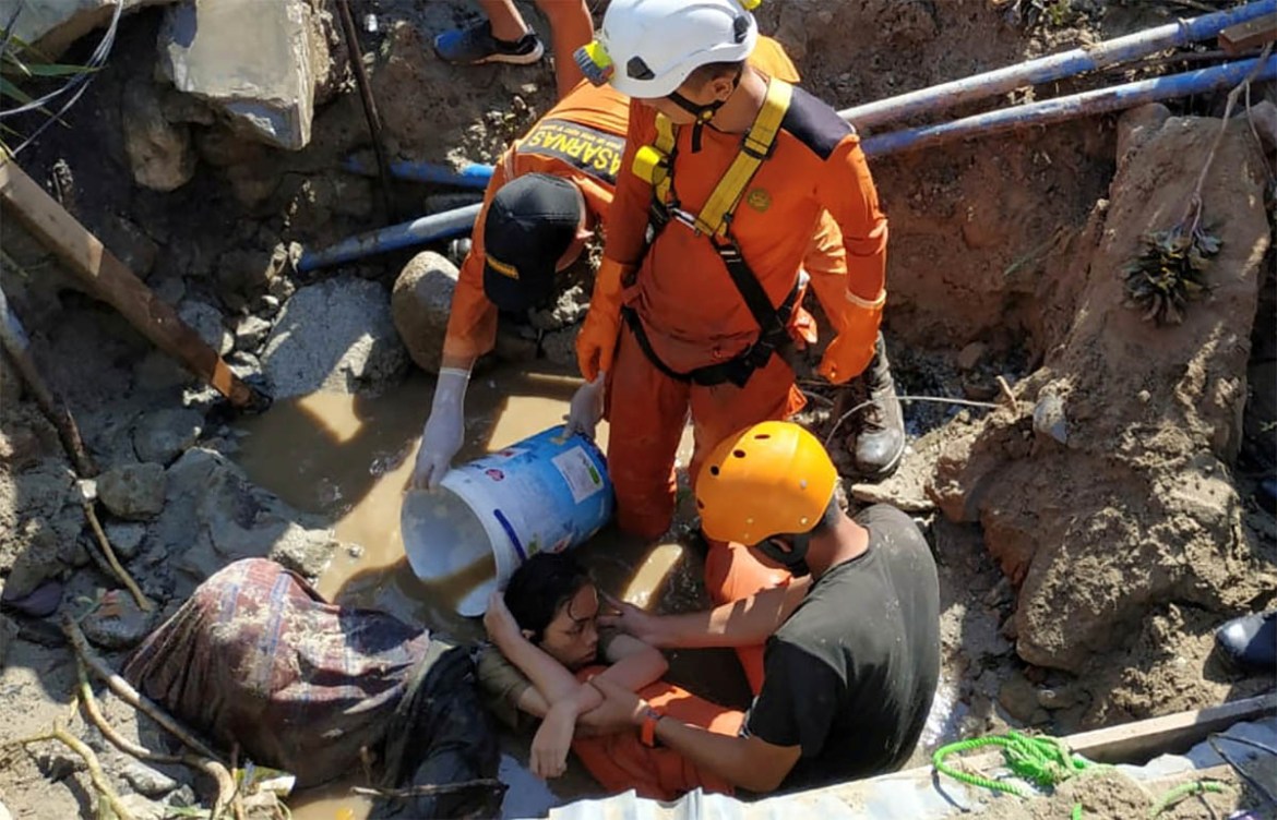 Search and rescue workers help rescue a person trapped in rubble following an earthquake and tsunami in Palu, Central Sulawesi, Indonesia September 30, 2018 in this photo taken by Antara Foto. Antara